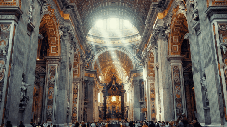 A imagem ilustra o interior da Basílica de São Pedro, invadido por raios de luz que entram pelas janelas localizadas na cúpula.