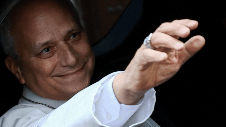 A imagem mostra o Papa Leão XIV dentro de um carro acenando pela janela
